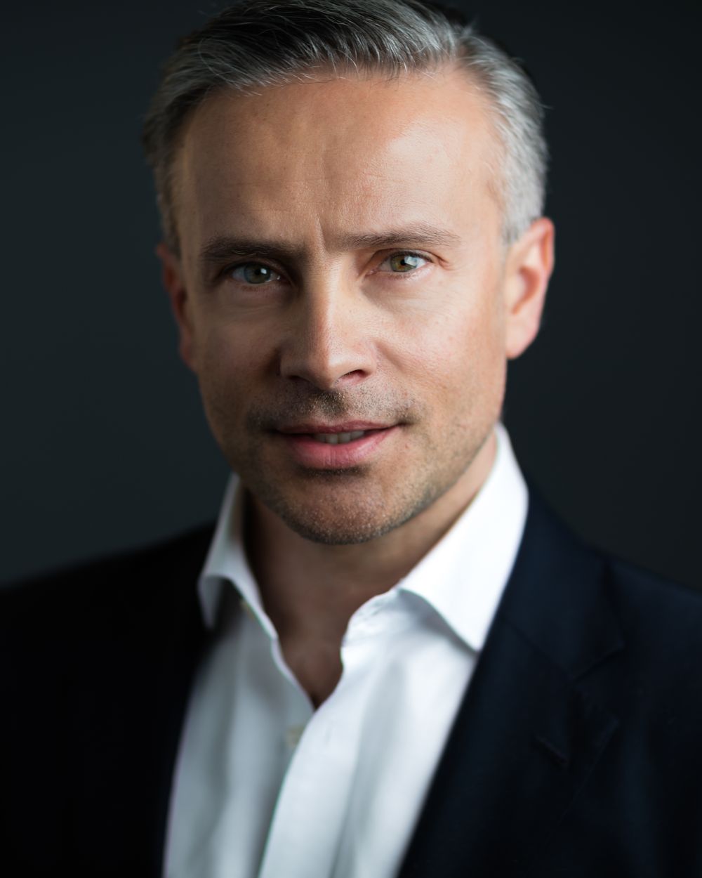 Commercial actor headshot in a suit and open collar for corporate and spokesperson roles, HeadshotDC
