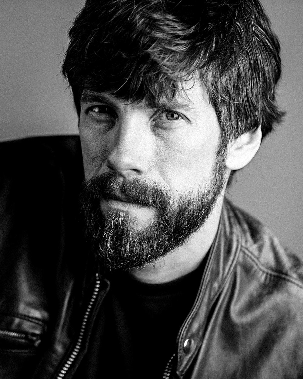 Black and white theatrical actor headshot with a beard and leather jacket, HeadshotDC Washington, DC