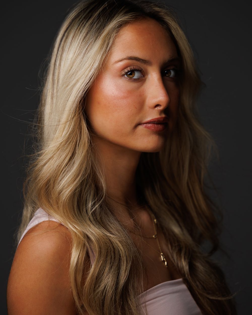 Dramatic low-key actress headshot with long hair on a dark backdrop, HeadshotDC Washington, DC