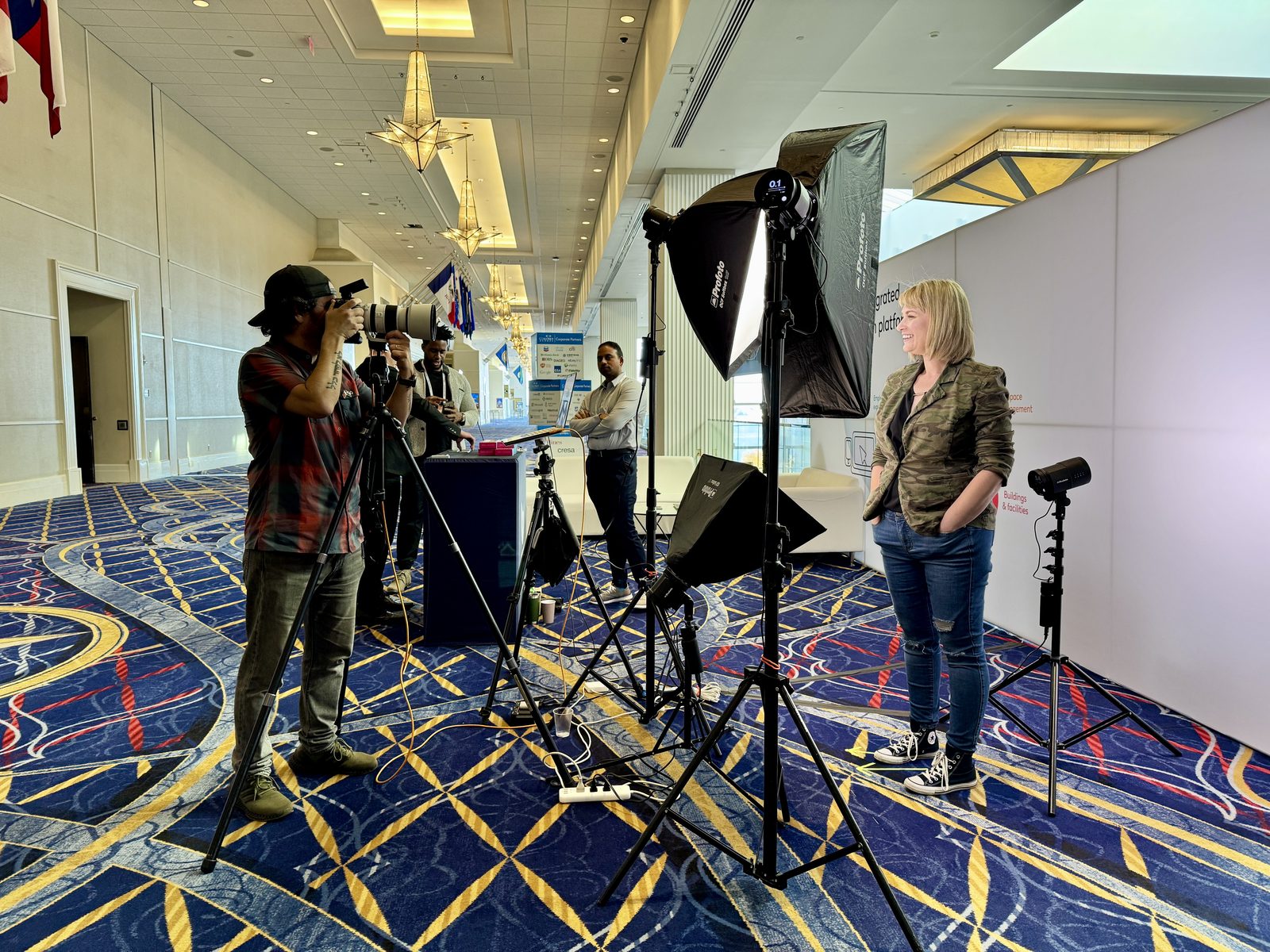 HeadshotDC photographer shooting an attendee headshot at a trade show with Profoto studio lighting and a clean backdrop